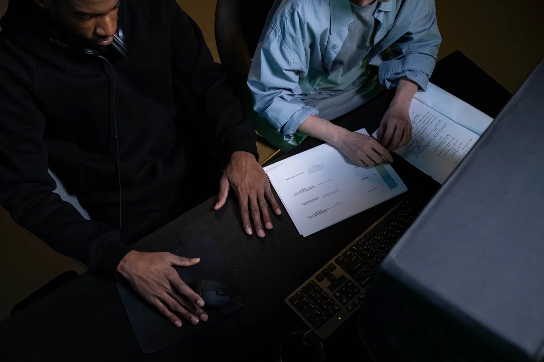 Team members reviewing documents and workflow materials at a desk.